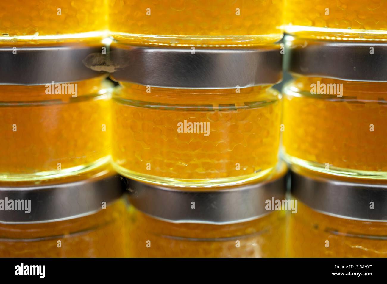 Small glass cans with real fish salmon and trout red, orange and yellow ...