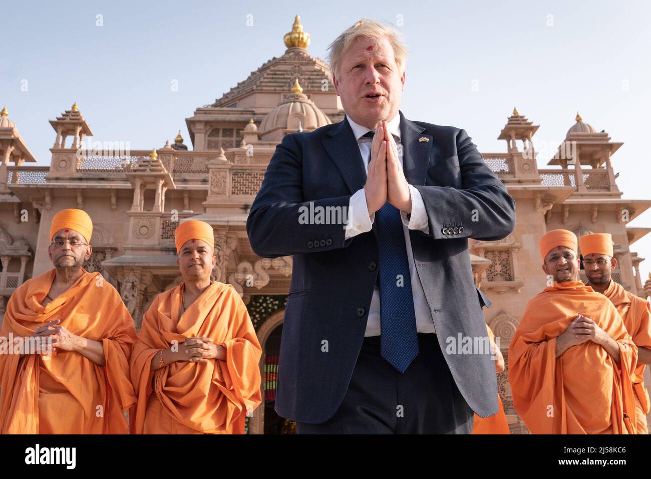 Shoeless Prime Minister Boris Johnson walks with sadhus, Hindu holymen, as he visits the Swaminarayan Akshardham temple in Gandhinagar, Ahmedabad, as part of his two day trip to India. Picture date: Thursday April 21, 2022. Stock Photo