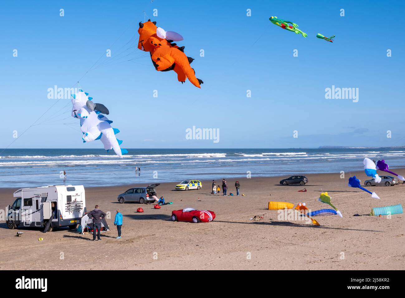 Inflatable cartoon figures in the sky above Benone Strand in Northern Ireland - being patrolled by local police. Stock Photo