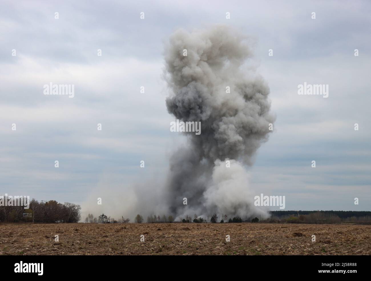 KYIV REGION, UKRAINE - APRIL 20, 2022 - Smoke rises over the site of the controlled detonation during the disposal of ammunition collected in the terr Stock Photo