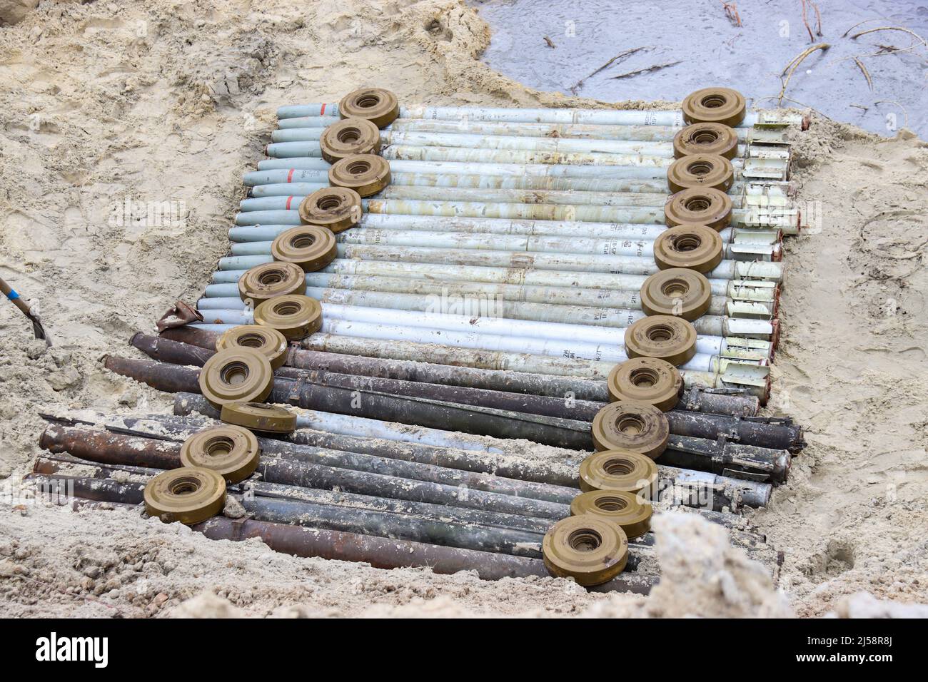 KYIV REGION, UKRAINE - APRIL 20, 2022 - Land mines press down missiles arranged on the ground during the disposal of ammunition collected in the terri Stock Photo