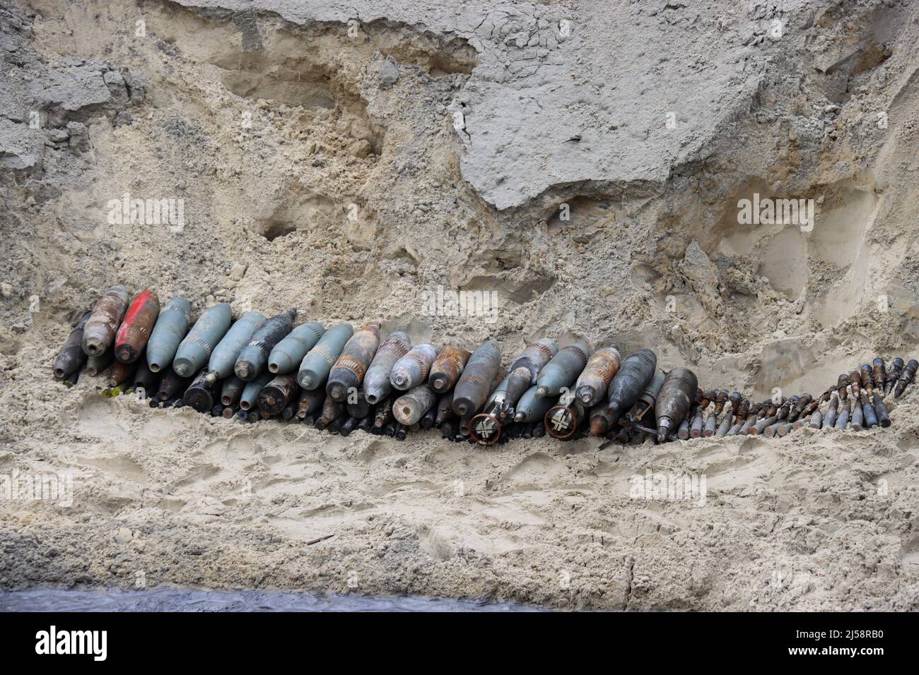 KYIV REGION, UKRAINE - APRIL 20, 2022 - Shells are pilled on the ground during the disposal of ammunition collected in the territories liberated from Stock Photo