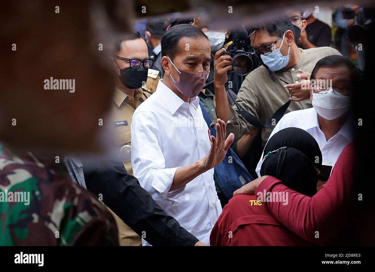 Bogor, Indonesia. 21st Apr, 2022. Indonesian President Joko Widodo (c) during distribution of Cooking Oil Direct Cash Assistance (BLT) for residents at a traditional market In Bogor, West Java, Indonesia on April 21, 2022. The President handed over BLT Cooking Oil of Rp300,000 to the participants of the Family Hope Program (PKH), street vendors, and market traders. In addition, President Jokowi also distributed Working Capital Assistance of Rp1.2 million for additional working capital or business capital. (Photo by Ryan Maulana/INA Photo Agency/Sipa USA) Credit: Sipa USA/Alamy Live News Stock Photo