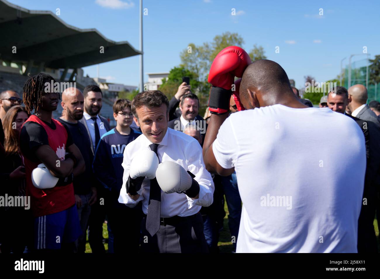 French President and La Republique en Marche (LREM) party candidate for  re-election Emmanuel Macron trains with amateur boxer Jean-Denis Nzaramba,  23, in the Auguste Delaune stadium in Saint-Denis, a northern suburb of