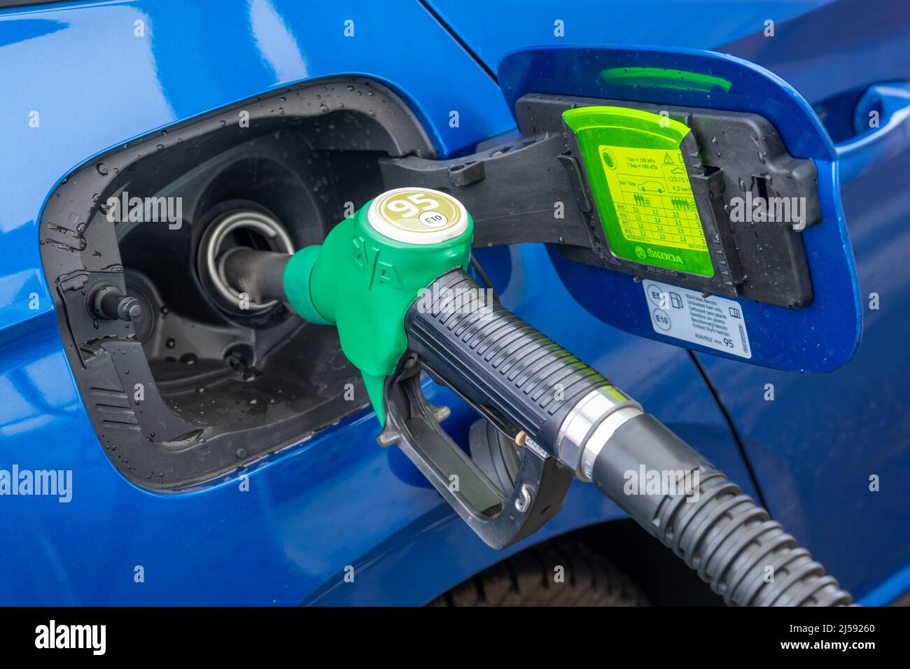 Refilling of blue modern Skoda car at petrol station with gasoline. Increasing price and oil embargo concept, April 2022, Prague, Czech Republic Stock Photo