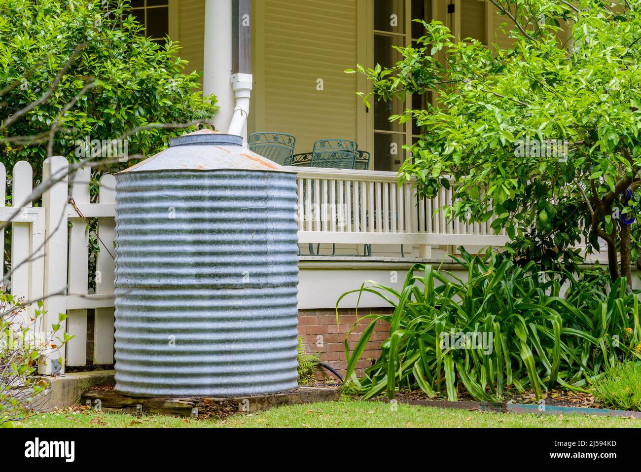 Sheet metal rain barrel next to porch on front of house in New Orleans