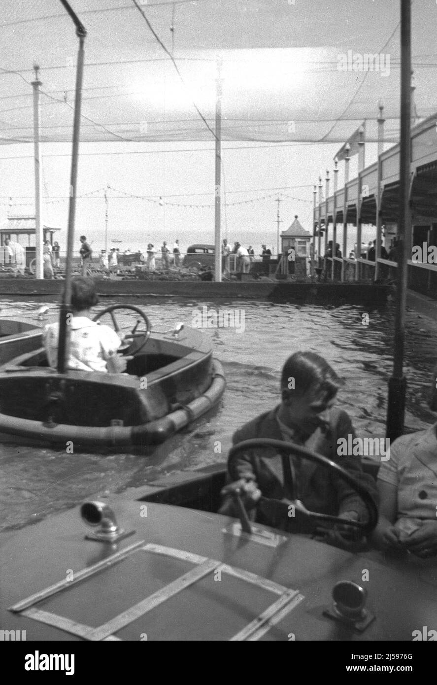 1950s, historical, holiday makers having fun in the small wooden boats on the boating pool at the famous beach Dreamland pleasure park at Margate, Kent, England, UK. Stock Photo