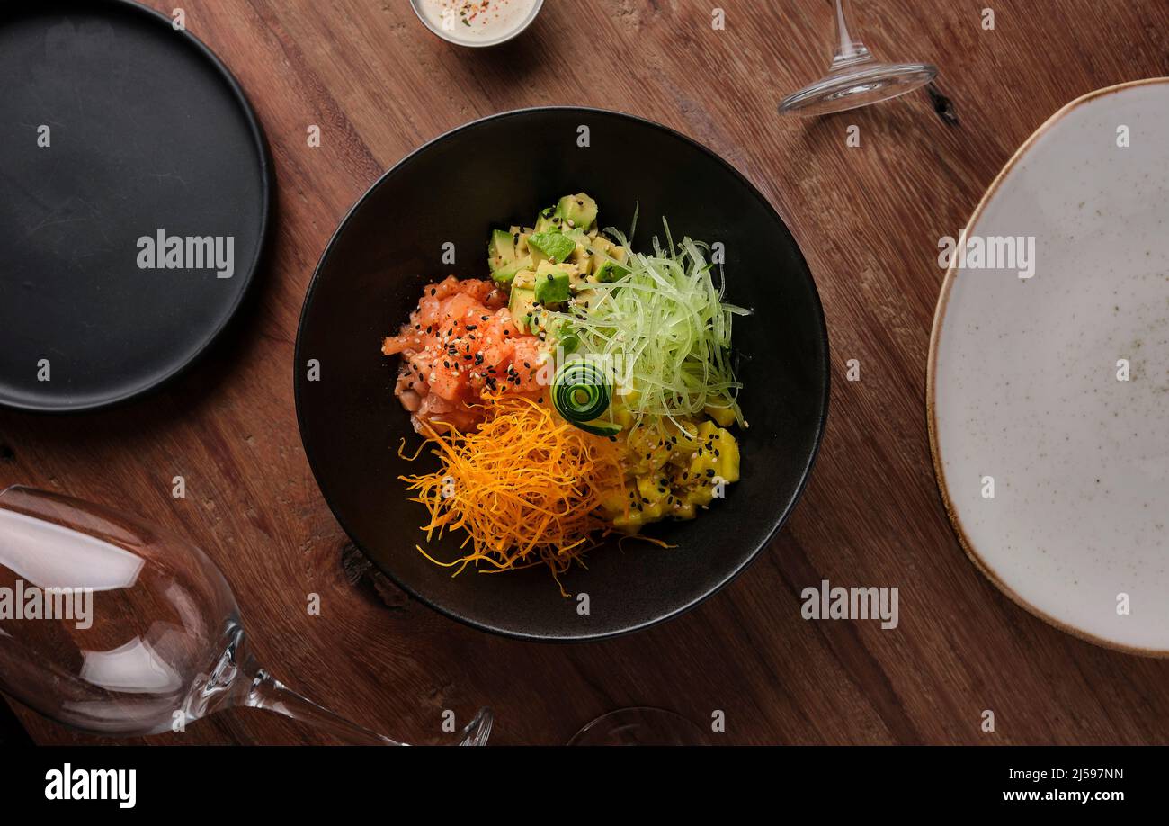 Poke bowl, traditional Hawaiian raw salmon fish salad, with chopsticks and copy space. Selective focus. Stock Photo