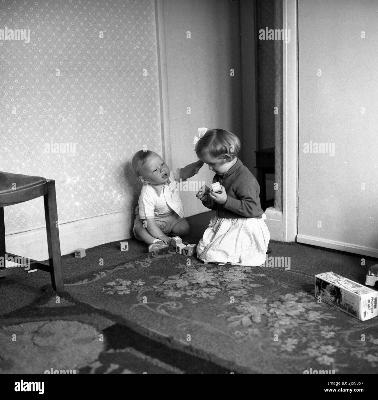 1962, historical, small children, brother and sister playing wooden alphabet letter blocks in a front room, England, UK. Stock Photo