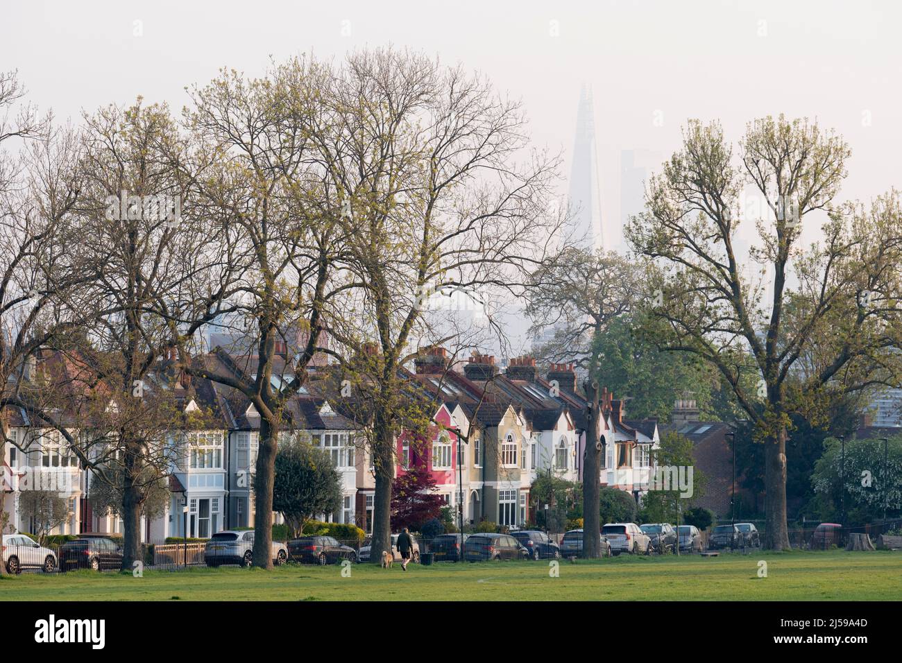 Terraced period homes and the Shard seen from Ruskin Park, a south London green space in Lambeth, on 21st April 2022, in London, England. Stock Photo
