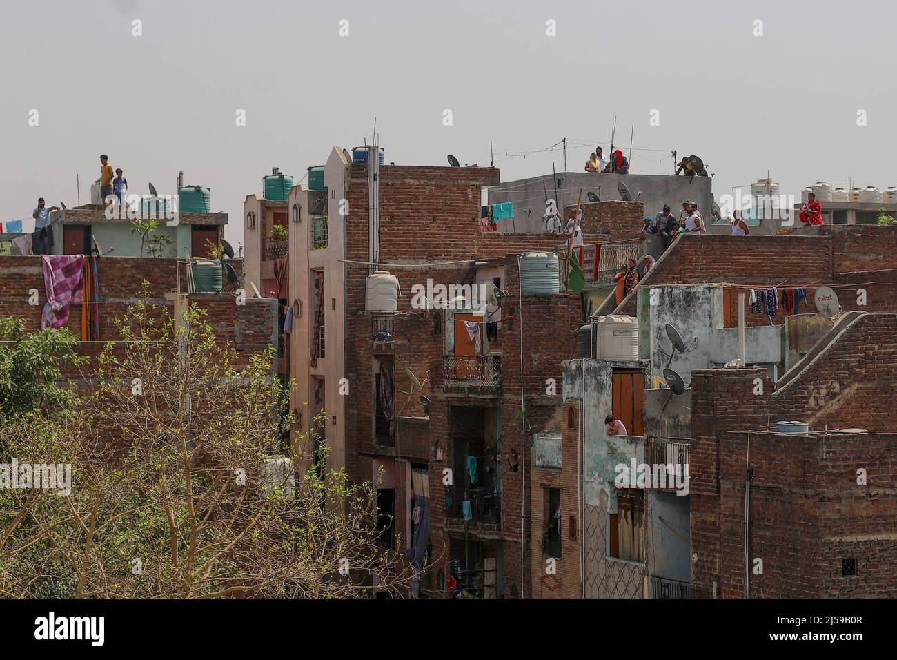 New Delhi, India. 20th Apr, 2022. Residents on top of buildings watching the demolition of illegal construction in the high-tension area that witnessed communal violence between two groups during a Hanuman Jayanti procession, in New Delhi's Northwest Jahangirpuri neighborhood, India. (Credit Image: © Amarjeet Kumar Singh/SOPA Images via ZUMA Press Wire) Stock Photo
