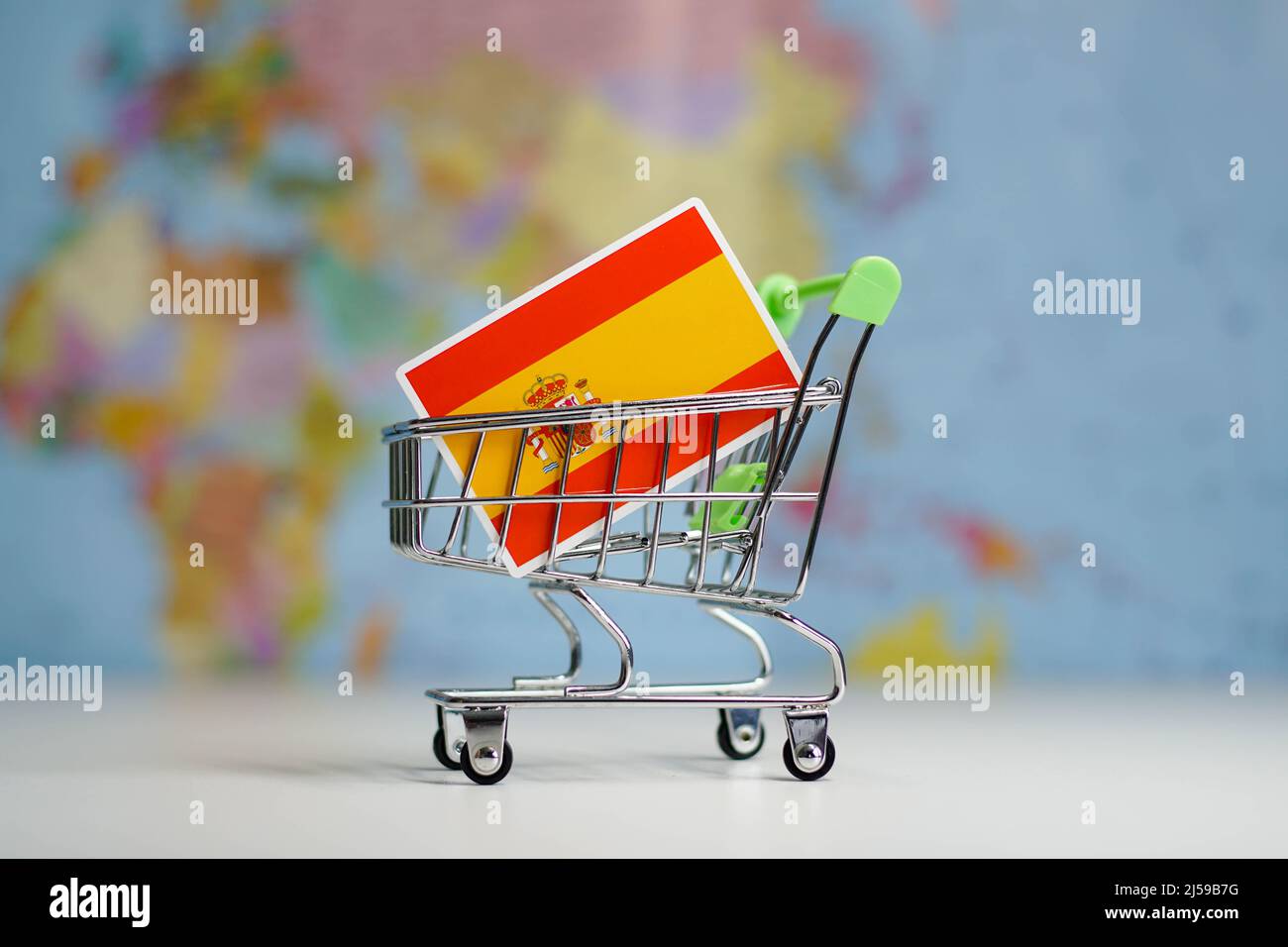 Spain national flag in miniature shopping trolley cart. Shopping online