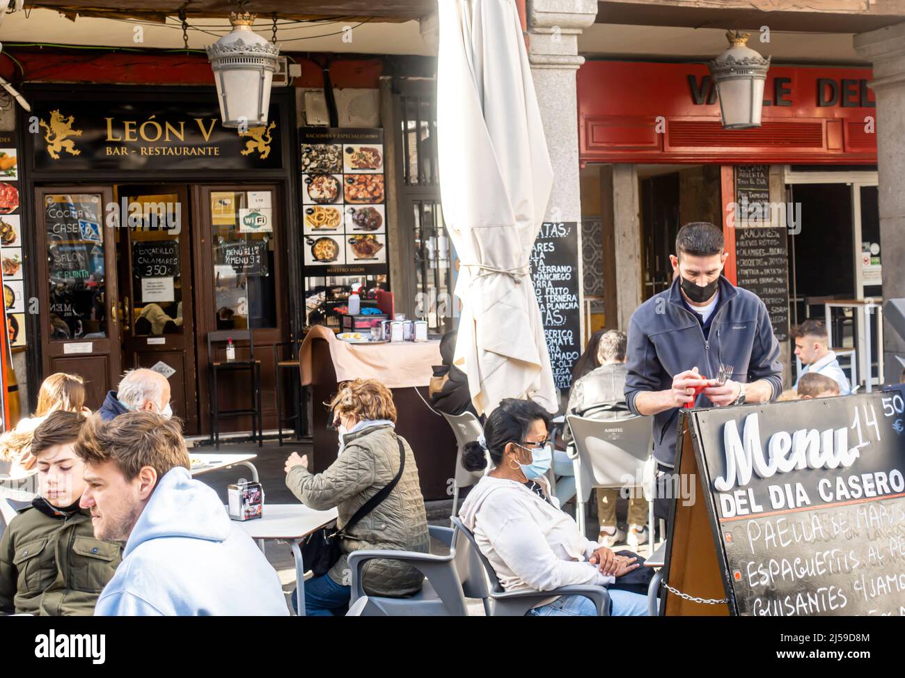 Restaurant Leon V, near Plaza Mayor, Madrid, Spain. Waiter and patrons in face masks Stock Photo