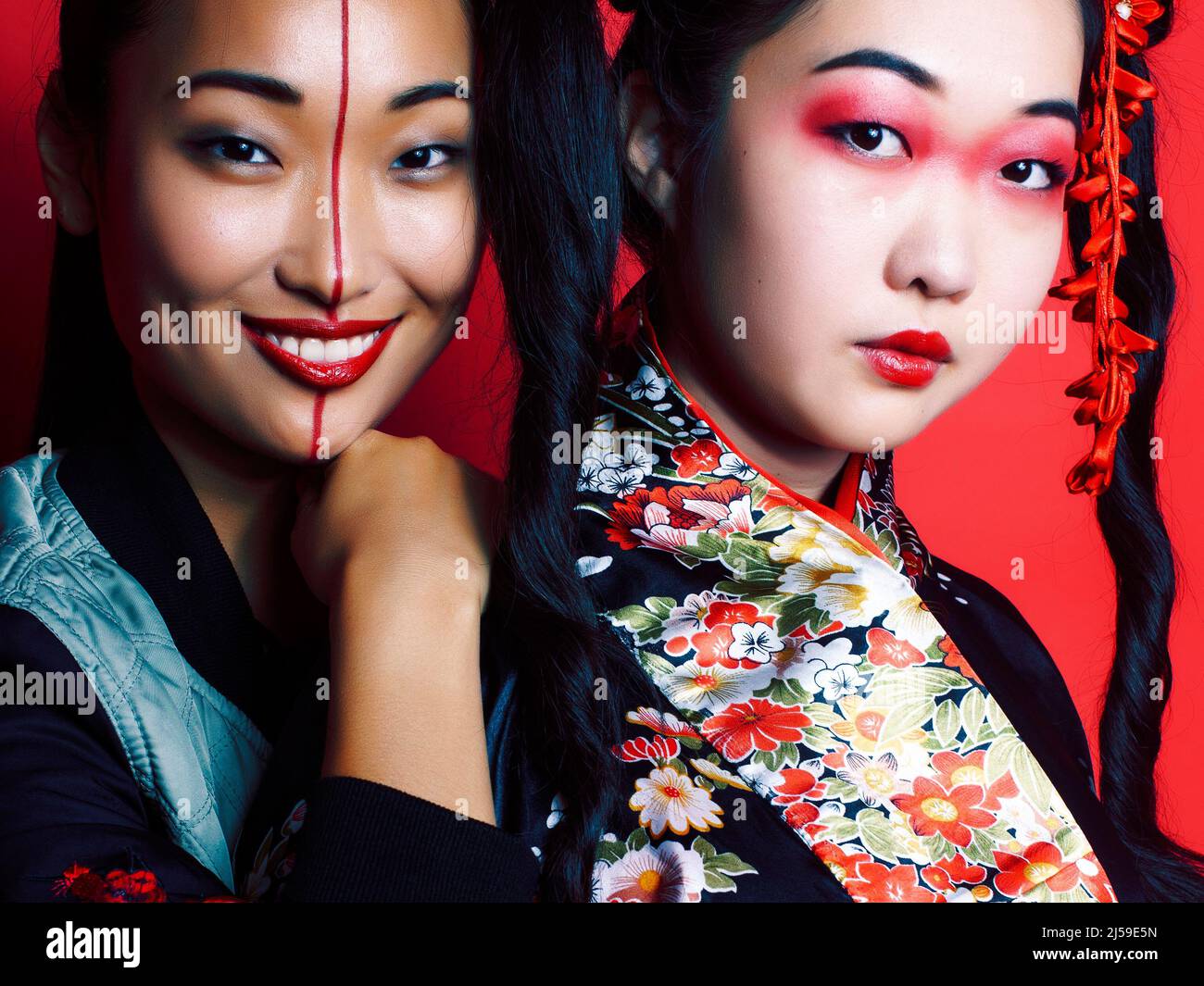 two pretty geisha friends: modern asian woman and traditional wearing ...