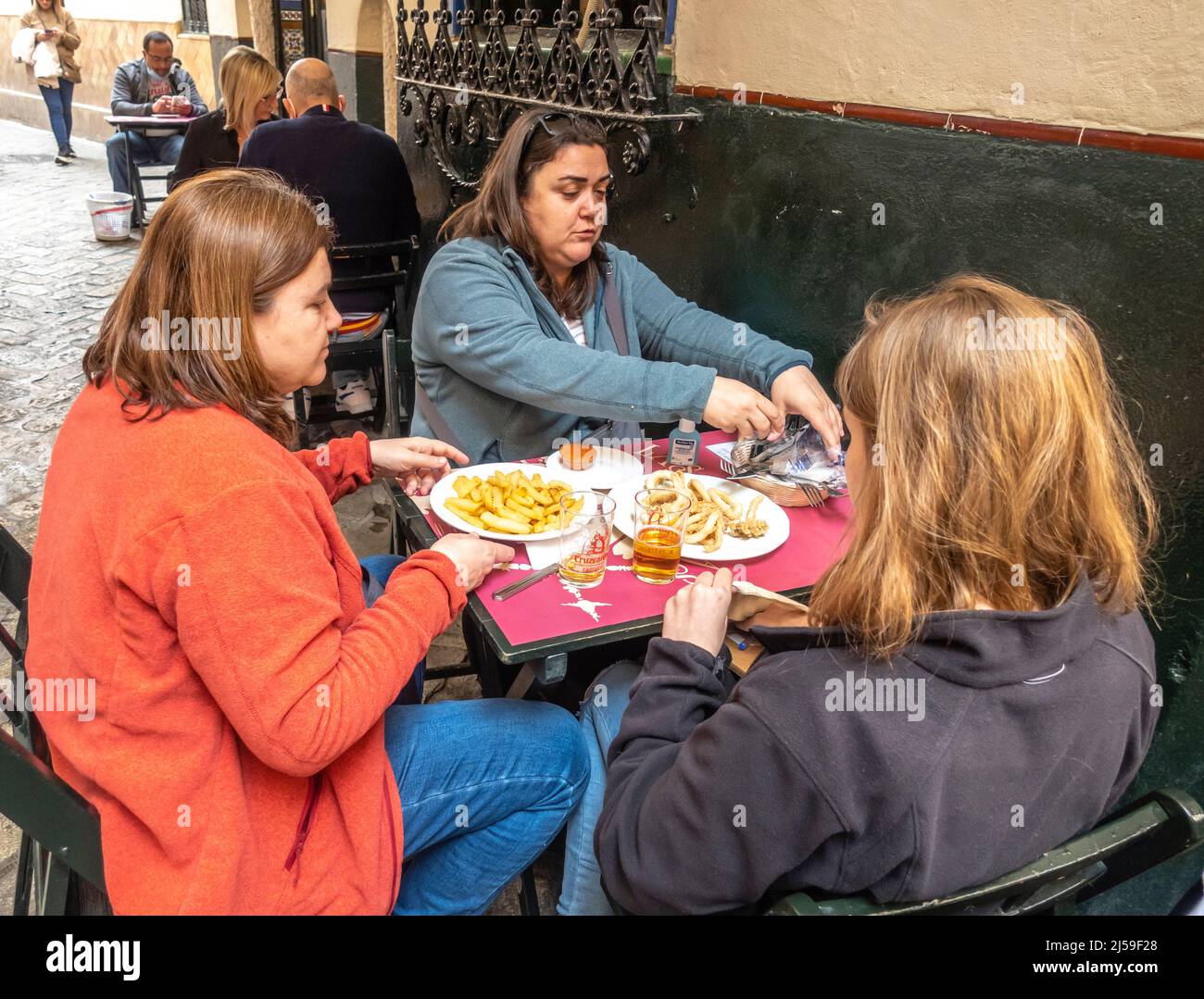 Guests enjoying Andalusian cuisine food in Tapas Bar Casa Placido in barrio Santa Cruz, central Sevilla, Spain Stock Photo