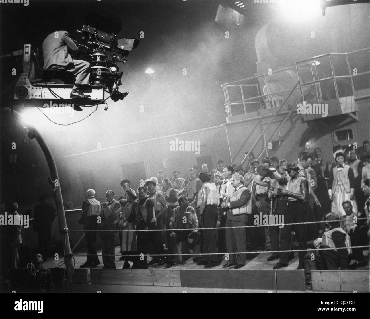 Camera Crew on Crane on set candid filming Crowd Scene on Ship Deck Set during filming of TITANIC 1953 director JEAN NEGULESCO writers Charles Brackett Walter Reisch and Richard L. Breen director of photography Joe MacDonald costume design Dorothy Jeakins art direction Maurice Ransford and Lyle R. Wheeler producer Charles Brackett Twentieth Century Fox Stock Photo