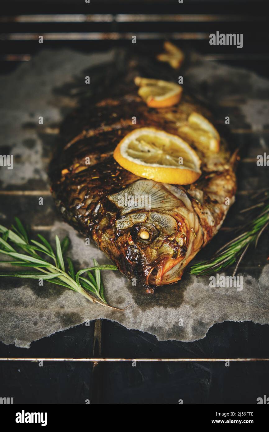 Fish baked in oven with lemon and rosemary on parchment paper, laid out