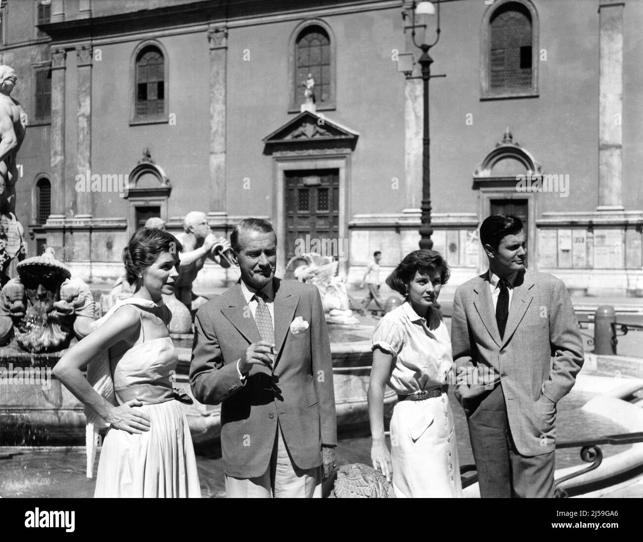 DOROTHY McGUIRE CLIFTON WEBB JEAN PETERS and LOUIS JORDAN on set location candid in August 1953 near the Trevi Fountain in Rome during filming of THREE COINS IN THE FOUNTAIN 1954 director JEAN NEGULESCO novel John H. Secondari screenplay John Patrick costumes designed by Dorothy Jeakins music Victor Young producer Sol C. Siegel Twentieth Century Fox Stock Photo