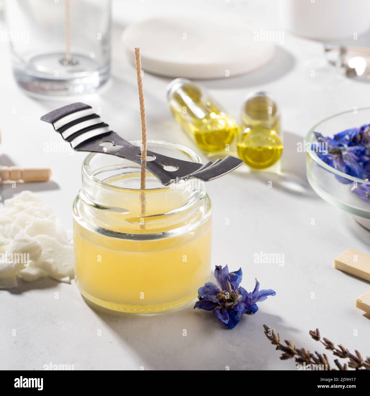 Set tools for homemade natural eco-friendly soy wax candles, wick, perfume, essential oil on a marble table. Making process. Trendy DIY. Craft hobby Stock Photo
