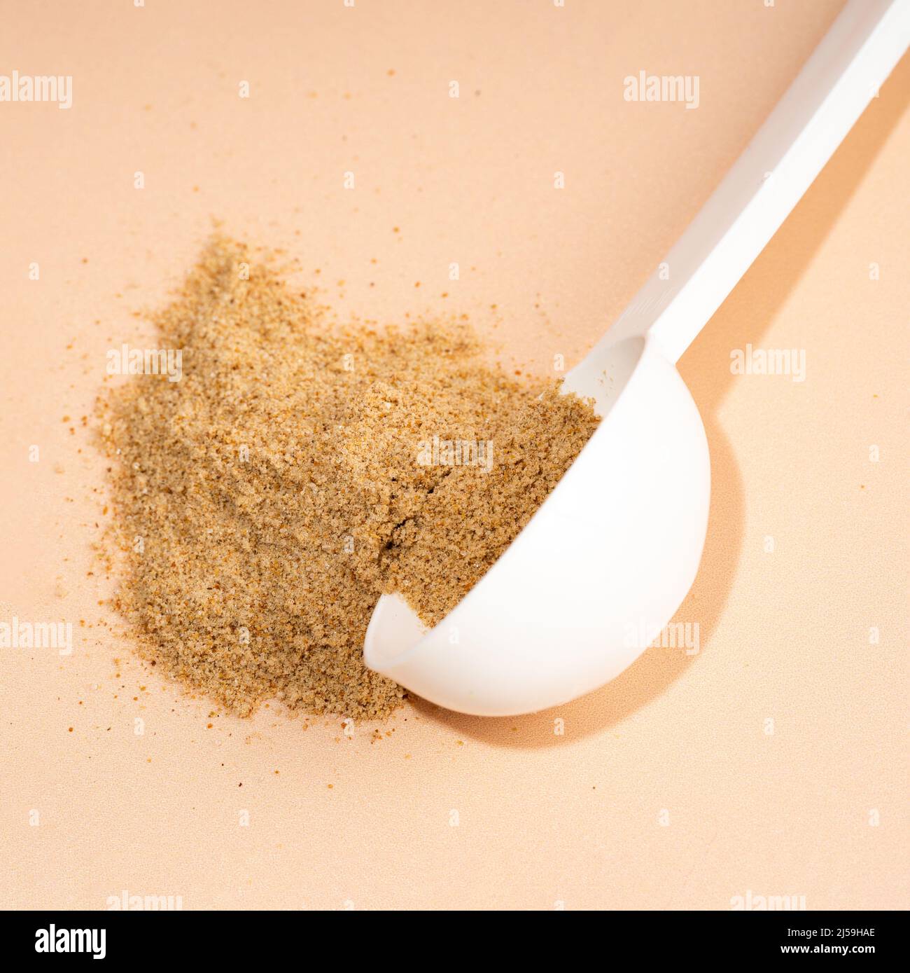 Mixture of dietary fiber supplement . White scoop of dietary fiber on a beige background. Dietary herbal supplements. Biologically active additives Stock Photo
