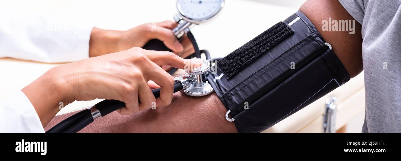 Close-up Of Female Doctor's Hand Checking Blood Pressure Stock Photo