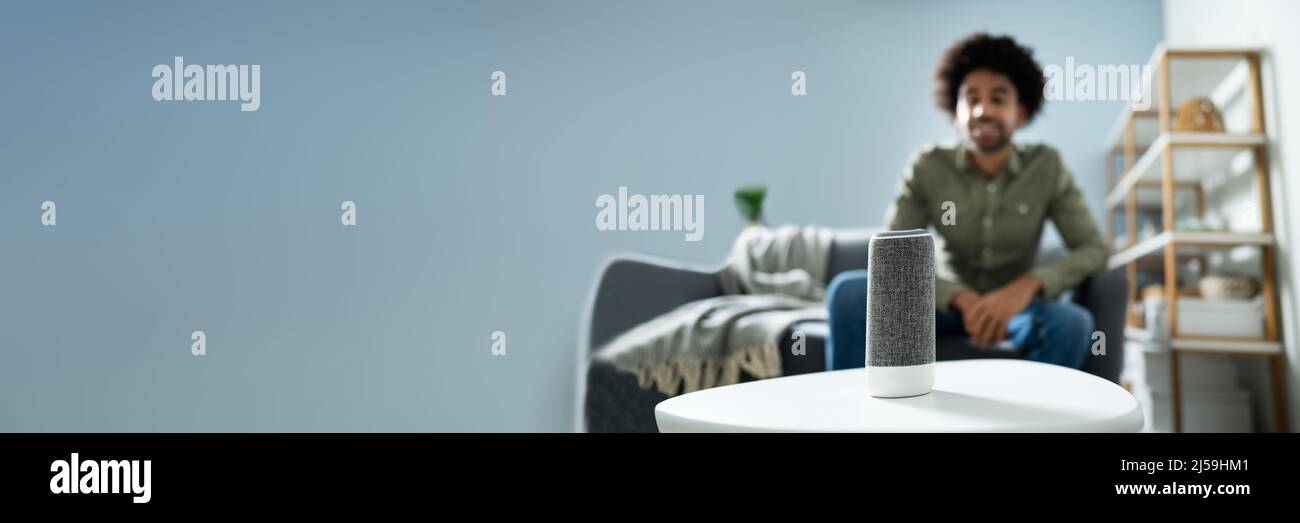 Young Man Using Wireless Speaker At Home Stock Photo