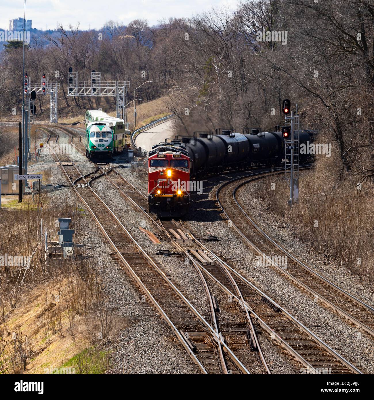 Freight train and commuter passenger train on railway tracks. Hamilton