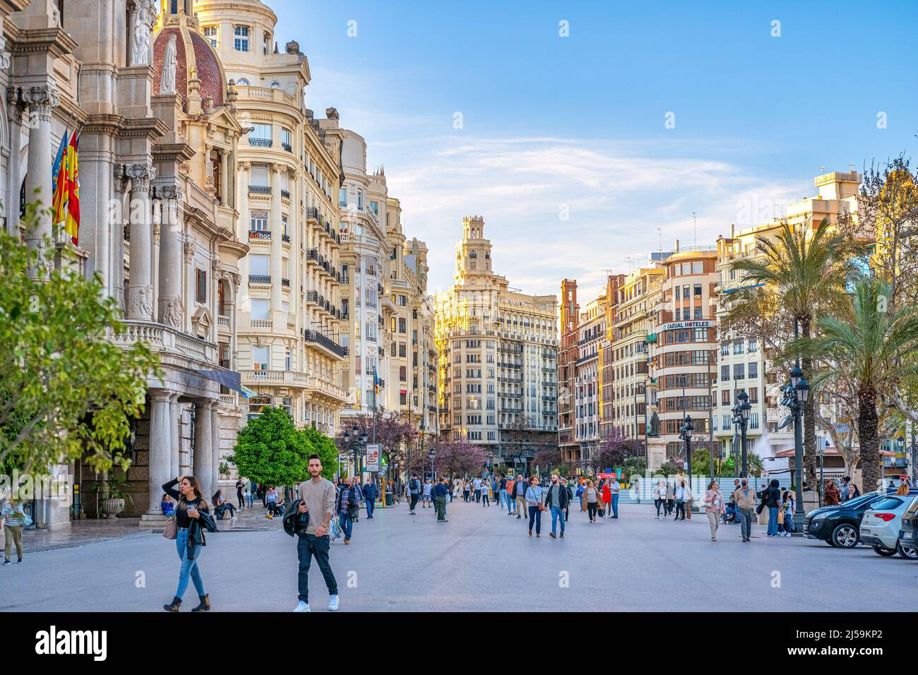 Large group of tourists or people are seen out and about in the Plaza del Ayuntamiento or City Hall Town Square. Majestic colonial architecture buildi Stock Photo