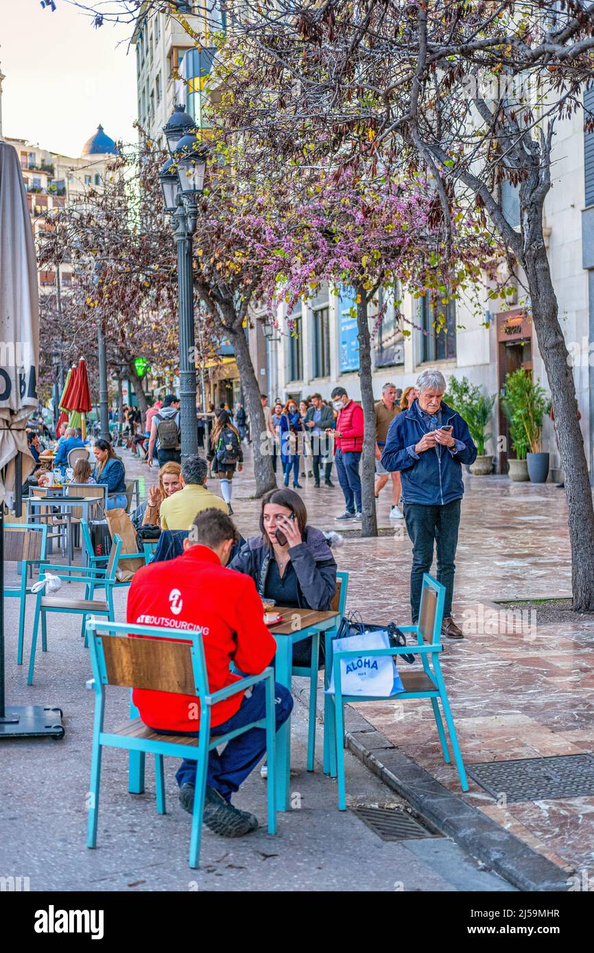 Tourists or people are seen sitting in an outdoor restaurant patio in the old town. This residential and commercial district is a famous place and a t Stock Photo