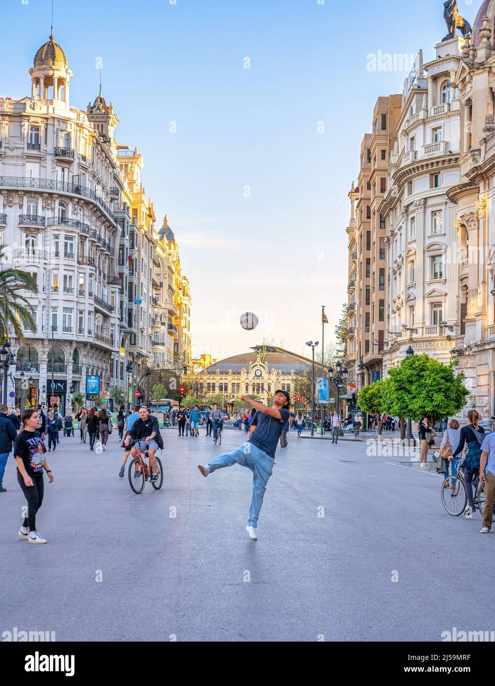 Young people playing with a soccer ball in the Plaza del Ayuntamiento or City Hall Plaza. The town square is surrounded by majestic colonial style bui Stock Photo