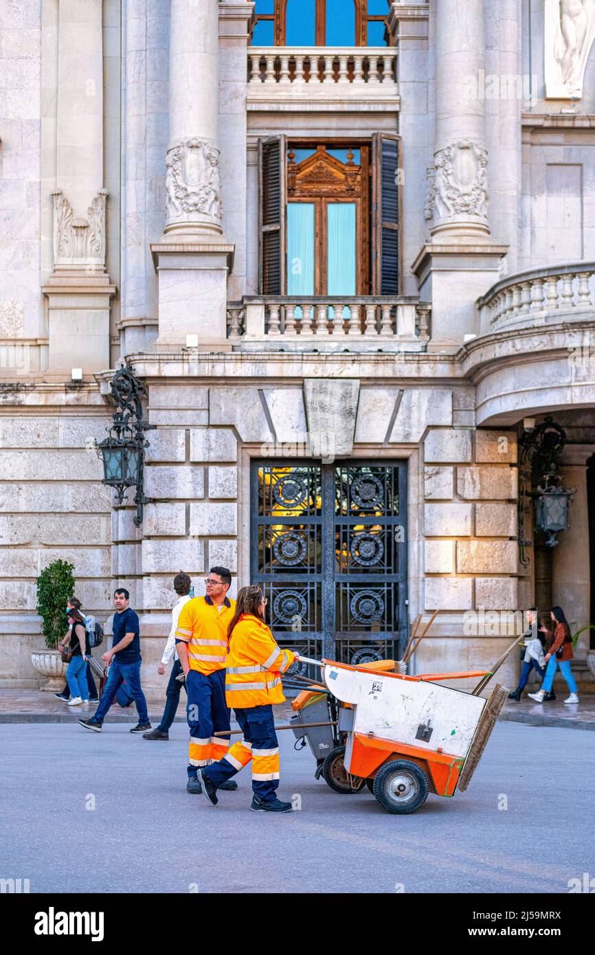 Two workers are seen with cleaning or maintenance carts in the Casa Consistorial or City Hall. The building is located in the Plaza del Ayuntamiento o Stock Photo