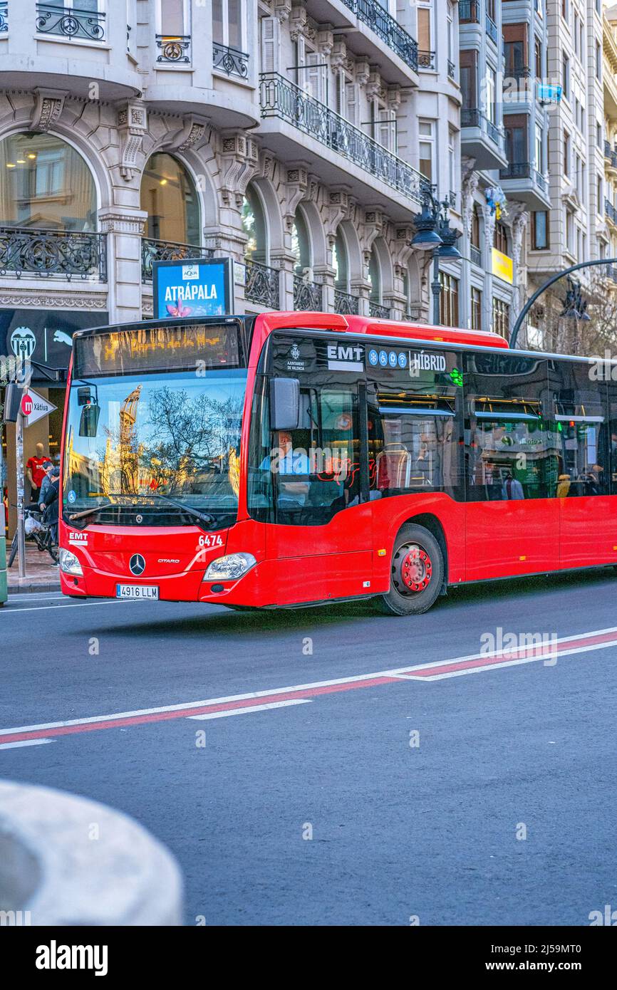 A Mercedes Benz urban transportation bus drives in the old town. Colonial style buildings are seen in the background. This residential district is a f Stock Photo