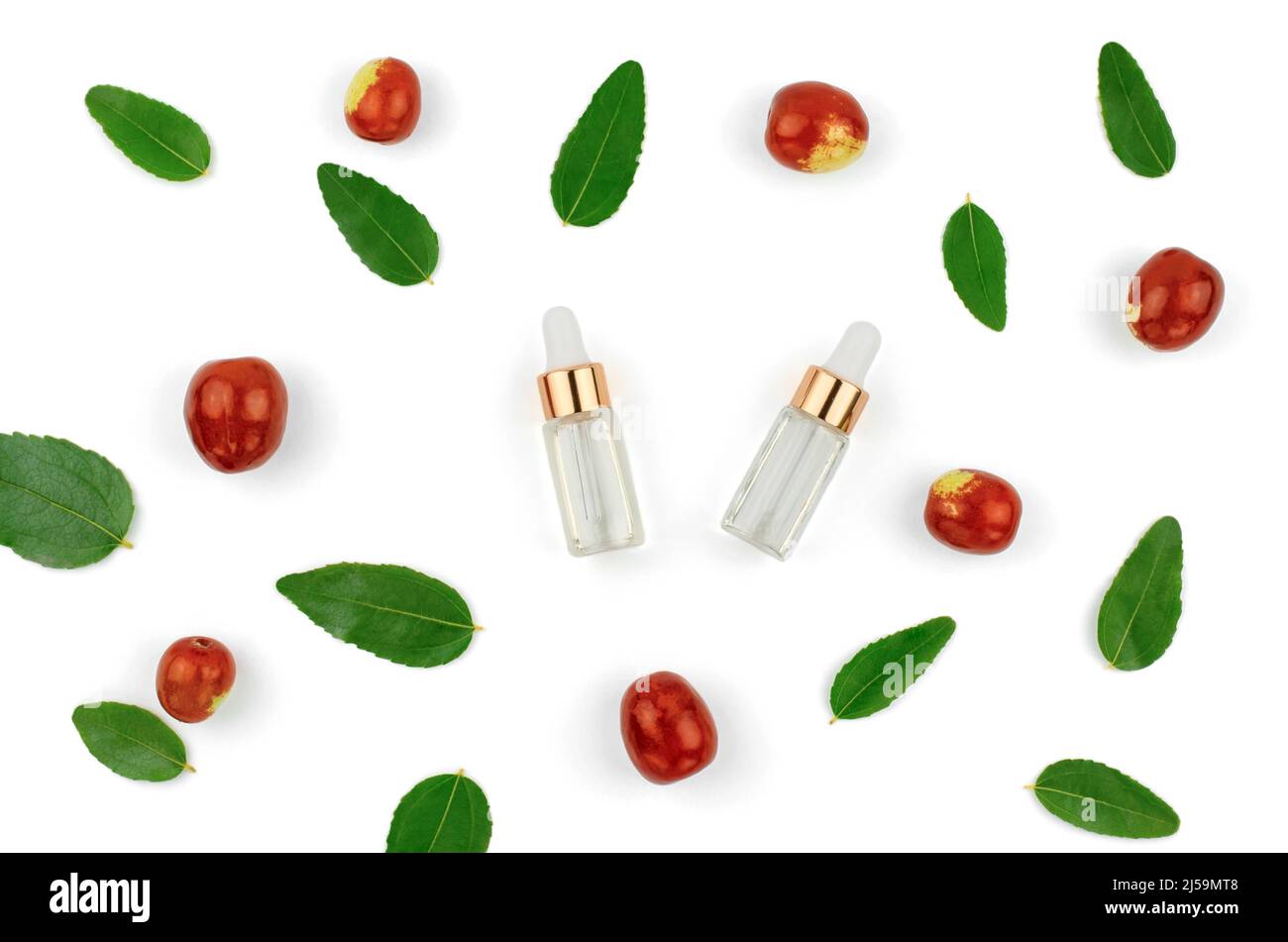 Chinese date fruit and oil. Jojoba oil in a transparent bottle with a dropper and fresh jojoba fruit on a white background. Stock Photo