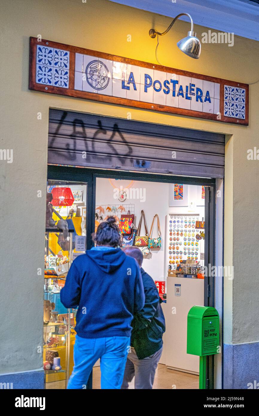 Two people are seen at the entrance door of La Postaleria. The business is located in the old town. This centric district is a famous place and a majo Stock Photo