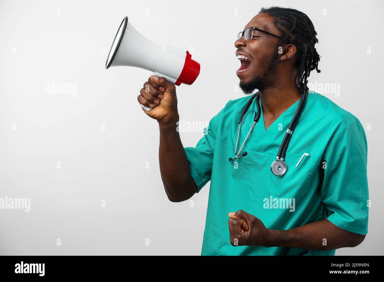 Young black doctor in green uniform using speaker. Stock Photo