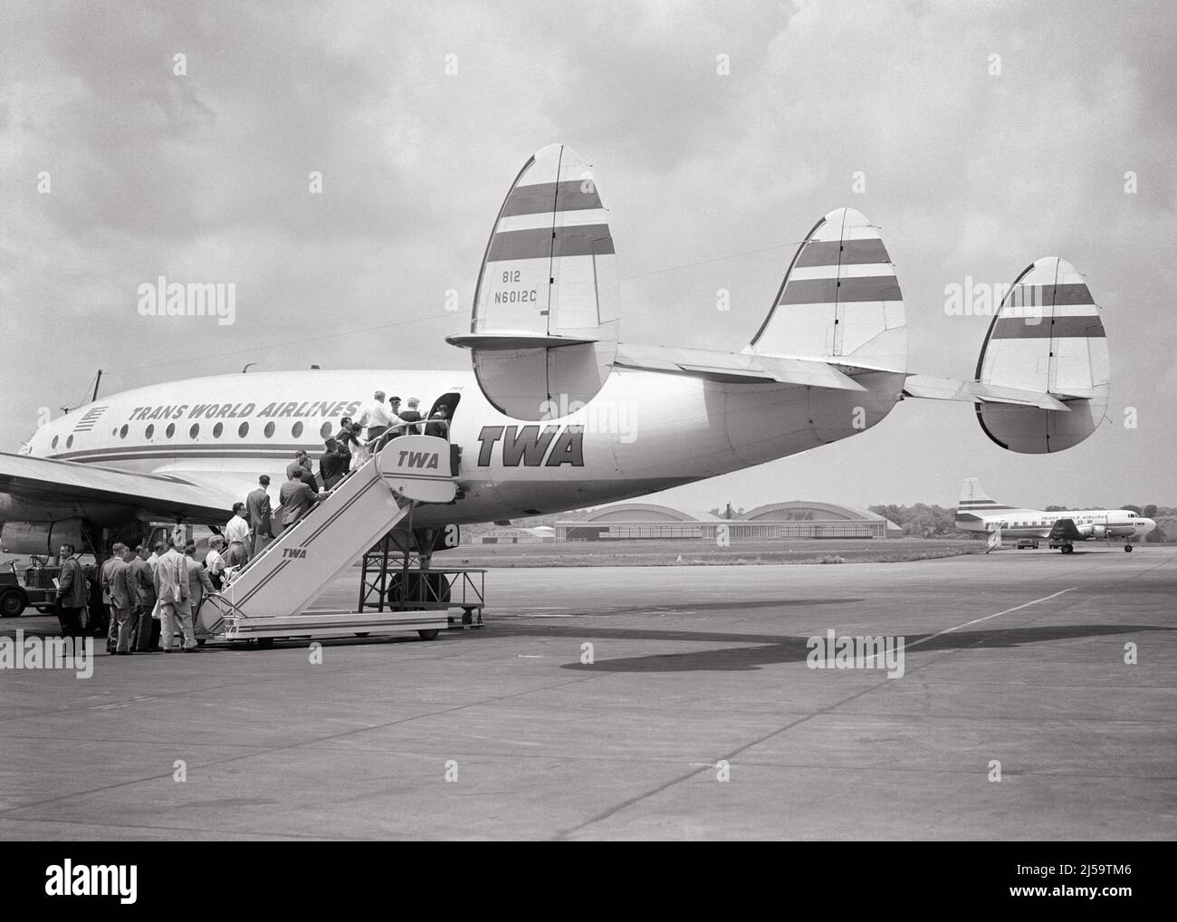 1950s PASSENGERS BOARDING A TWA CONSTELLATION STYLE AIRCRAFT BY STAIRWAY LADDER ENTRY ON THE TARMAC - a74 CRS001 HARS LADIES PERSONS MALES TRANSPORTATION B&W FREEDOM WIDE ANGLE ADVENTURE AIRPLANES CUSTOMER SERVICE EXTERIOR LOW ANGLE POWERFUL PROGRESS INNOVATION PRIDE TARMAC AVIATION STAIRWAY 1943 CONCEPTUAL CONSTELLATION STYLISH TWA ENTRY LOCKHEED TRANS WORLD AIRLINES AIRLINER BLACK AND WHITE OLD FASHIONED SLEEK Stock Photo