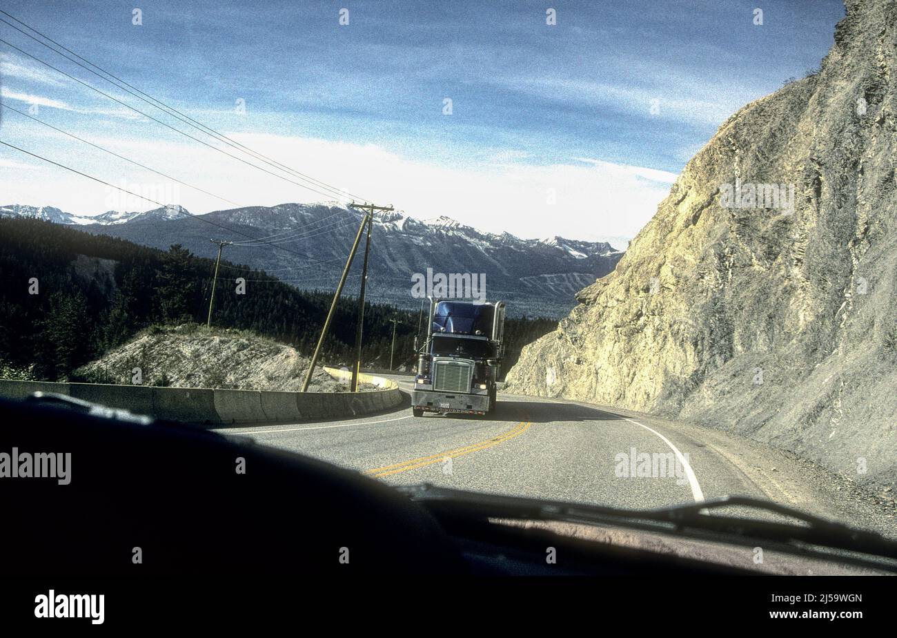 Large truck crossing the Rockies in Alberta, seen through windscreen of approaching vehicle. Stock Photo