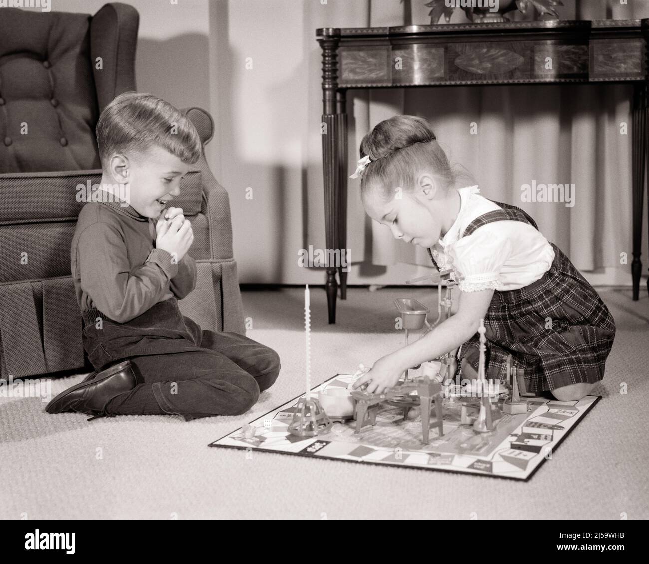 1960s LITTLE BOY AND GIRL BROTHER AND SISTER SITTING ON LIVING ROOM FLOOR PLAYING THE BOARD GAME MOUSE TRAP TOGETHER - j11898 HAR001 HARS HOME LIFE COPY SPACE FULL-LENGTH PERSONS MALES SIBLINGS CONFIDENCE SISTERS B&W SUCCESS HAPPINESS LEISURE STRATEGY LIVING ROOM AND EXCITEMENT RECREATION TRAP ON THE SIBLING MOUSE CONNECTION CONCEPTUAL STYLISH MOUSETRAP BOARD GAME GROWTH JUVENILES PRECISION RELAXATION TOGETHERNESS BLACK AND WHITE CAUCASIAN ETHNICITY HAR001 OLD FASHIONED Stock Photo