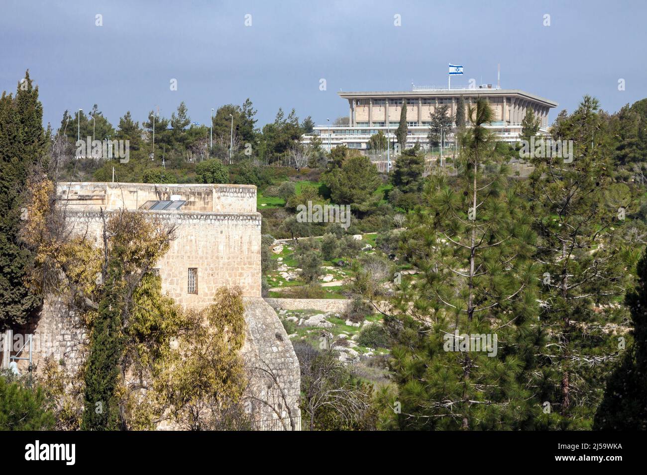 Knesset (the Parliament of Israel) with flying waving flag of Israel. The knesset located in Jerusalem neighborhood Givat Ram. Taken from Sderot Hayim Stock Photo