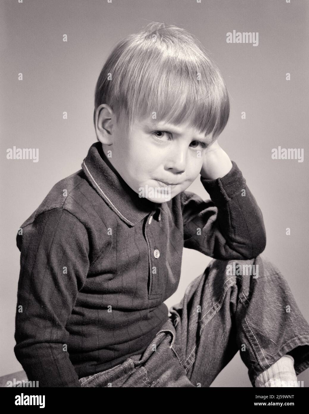 1960s CUTE LITTLE BLONDE BOY WITH POUTING PERTURBED ANGRY FACIAL EXPRESSION LOOKING AT CAMERA - j12332 HAR001 HARS LIFESTYLE ANNOYED WINNING STUDIO SHOT HOME LIFE COPY SPACE HALF-LENGTH MALES DENIM GESTURING EXPRESSIONS B&W SADNESS EYE CONTACT HUMOROUS DISTRESSED POUTING IRATE LEADERSHIP COMICAL PRIDE GESTURES CONCEPTUAL COMEDY POUT DISPLEASURE HOSTILITY PERTURBED PLEASANT AGREEABLE ANNOYANCE BLUE JEANS CHARMING EMOTION EMOTIONAL GROWTH INFORMAL IRRITATED JUVENILES LOVABLE PLEASING TWILL ADORABLE APPEALING BLACK AND WHITE CASUAL CAUCASIAN ETHNICITY DISPLEASED HAR001 OLD FASHIONED Stock Photo