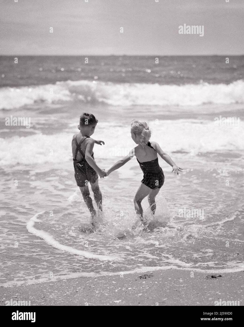 1950s 1960s Young Boy And Girl Brother And Sister Holding Hands Running 