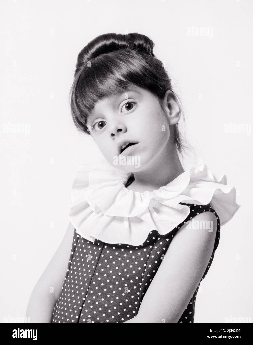 1960s ADORABLE BRUNETTE LITTLE GIRL LOOKING AT CAMERA QUESTIONING UNCERTAIN GAZE HAIR IN UPDO POLKA DOT DRESS HAS RUFFLED COLLAR - j13245 HAR001 HARS HALF-LENGTH B&W WIDE EYE CONTACT BRUNETTE DOT BUG-EYED POLKA UPDO STYLISH PLEASANT WIDE-EYED AGREEABLE CHARMING GAZE JUVENILES LOVABLE PLEASING POSE POSED QUESTIONING RUFFLED STARTLED ADORABLE APPEALING ATTITUDE BANGS BLACK AND WHITE CAUCASIAN ETHNICITY HAR001 OLD FASHIONED UNCERTAIN Stock Photo