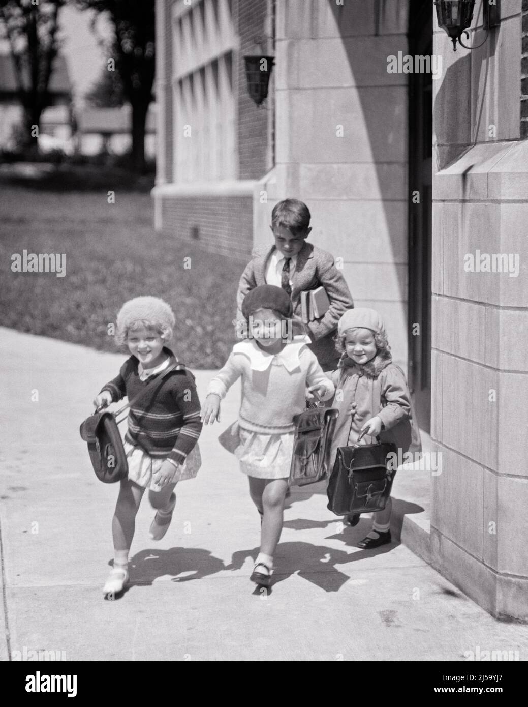 1930s FOUR KIDS RUNNING OUT OF SCHOOL BUILDING THREE GIRLS ONE BOY CARRYING BOOKS AND BOOK BAGS - j3930 HAR001 HARS 1 JUVENILE ELEMENTARY PLEASED JOY LIFESTYLE SATISFACTION ARCHITECTURE FEMALES HEALTHINESS COPY SPACE FRIENDSHIP FULL-LENGTH PERSONS CLOTH MALES BUILDINGS SUNNY DIAPER B&W FREEDOM SCHOOLS GRADE HAPPINESS CHEERFUL HIGH ANGLE PROPERTY VICTORY AND EXCITEMENT KNOWLEDGE MARY JANE DIAPERS END OF DAY PRIMARY SMILES SWEATERS REAL ESTATE STRUCTURES JOYFUL STYLISH EDIFICE BERETS GRADE SCHOOL GROWTH BLACK AND WHITE BOOK BAG CAUCASIAN ETHNICITY HAR001 OLD FASHIONED Stock Photo