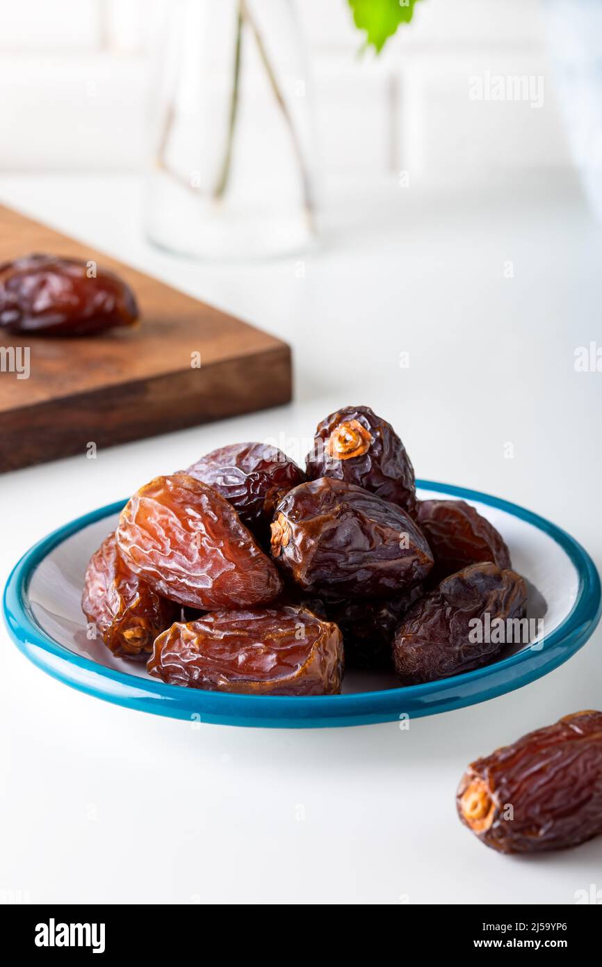 Dried dates in the bowl on white background. Stock Photo