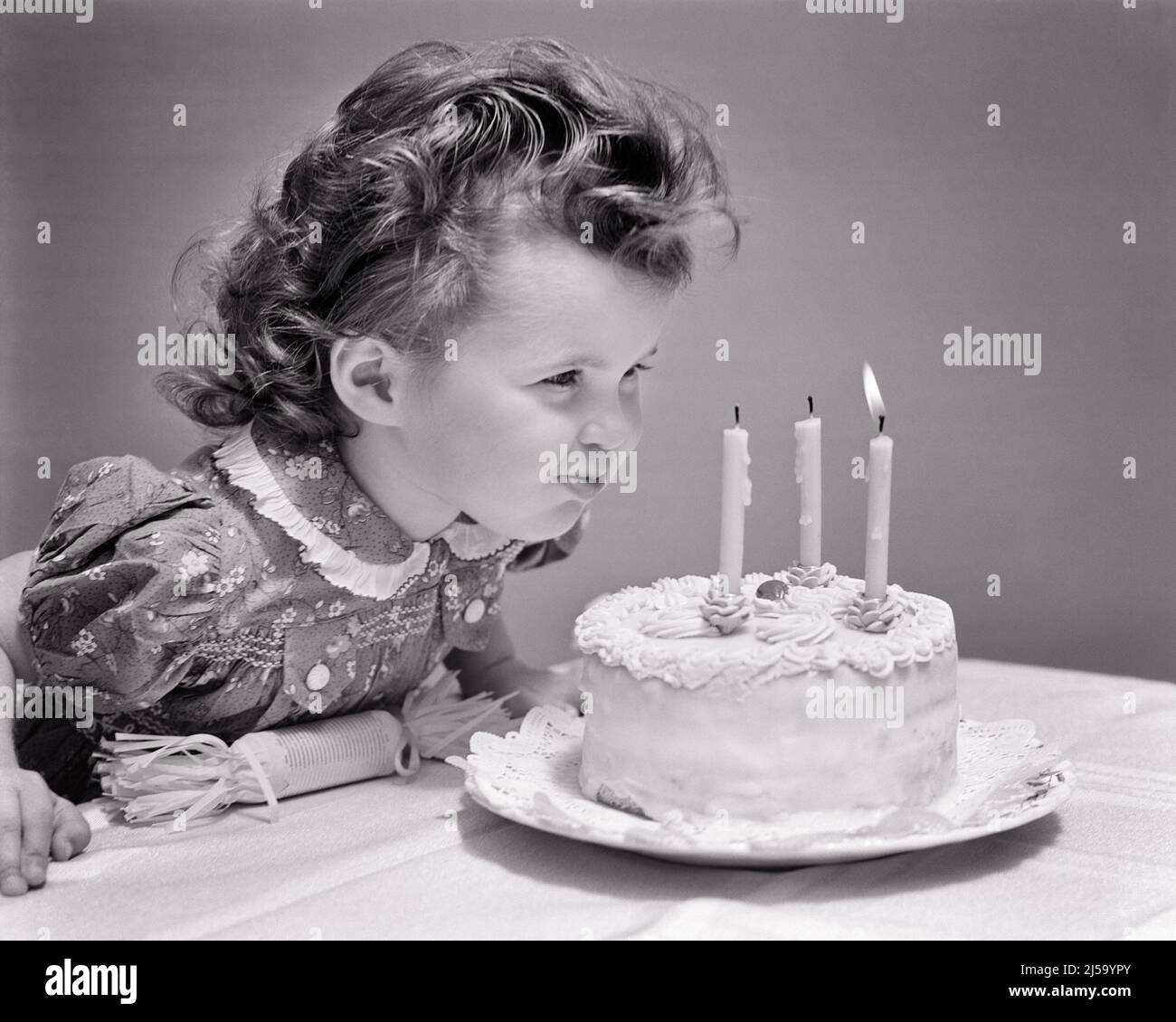 1930s 1940s CUTE THREE YEAR OLD GIRL BLOWING OUT THE CANDLES ON BIRTHDAY CAKE MAKING A WISH - j5443 HAR001 HARS COPY SPACE WISHING B&W BRUNETTE CELEBRATING HAPPINESS HEAD AND SHOULDERS CURLS EXCITEMENT BLOWING OUT WISH BLOW OUT PLEASANT AGREEABLE CHARMING GROWTH JUVENILES LOVABLE PLEASING ADORABLE APPEALING BLACK AND WHITE CAUCASIAN ETHNICITY CURLY HAIR HAR001 OLD FASHIONED Stock Photo