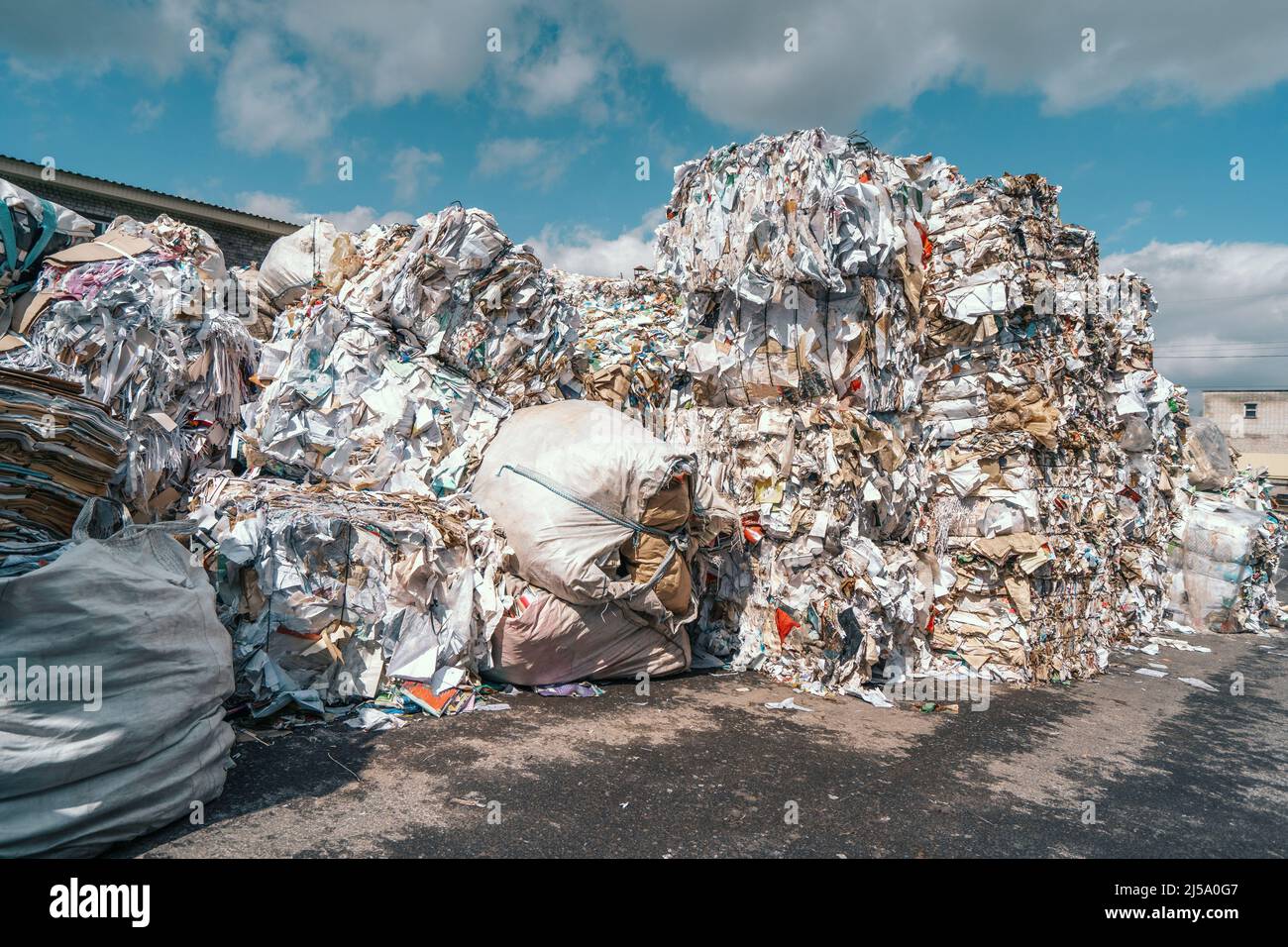 Heaps of waste paper, cardboard, newspapers and other paper waste folded for recycling. Reuse paper to save trees and ecology concept. Stock Photo