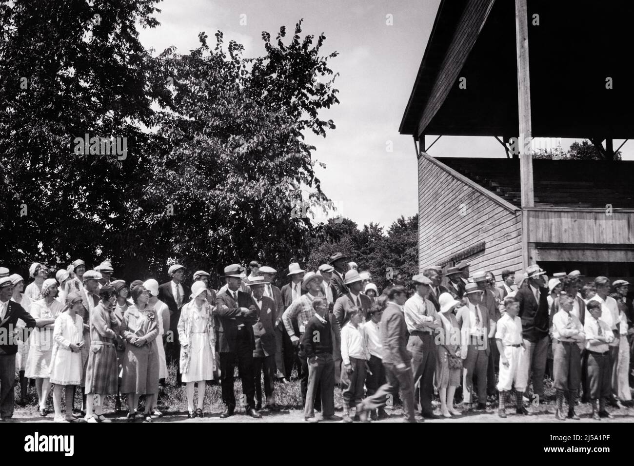 1920s CROWD OF PEOPLE SPECTATORS MEN WOMEN CHILDREN NEXT TO GRANDSTANDS AT CHENANGO COUNTY FAIRGROUNDS NORWICH NY USA - q75047 CPC001 HARS LIFESTYLE HISTORY CELEBRATION CROWDS FEMALES MARRIED ASSEMBLY EVENT SPOUSE HUSBANDS COPY SPACE FULL-LENGTH LADIES MASS COUNTY PERSONS MALES TEENAGE GIRL TEENAGE BOY ENTERTAINMENT NY NEXT SPECTATORS B&W GATHERING WIDE ANGLE RECREATION AT OF TO FAIRGROUNDS CONNECTION CONCEPTUAL GRANDSTANDS NEW YORK STYLISH GRANDSTAND JUVENILES SEASON THRONG TOGETHERNESS WIVES ATTENDANCE BLACK AND WHITE BRIDE AND GROOM OLD FASHIONED Stock Photo