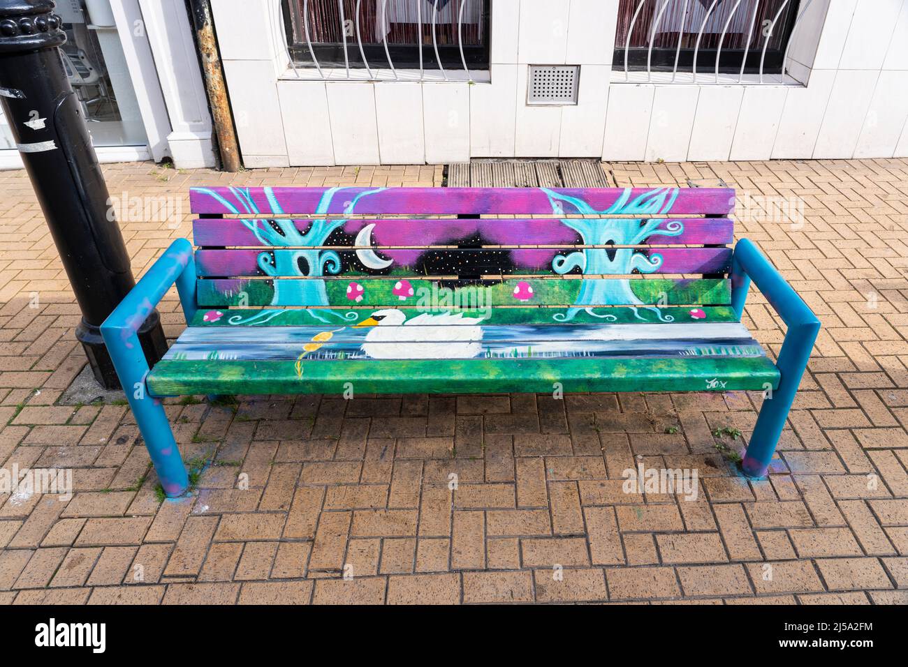 Hand painted mural on a bench on Winchester Road in Basingstoke town centre April 2022. Part of Streets Alive celebrating local artists. UK Stock Photo