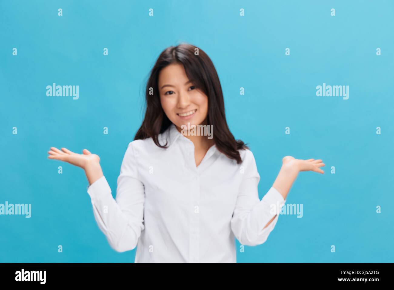Happy cute Asian businesswoman in classic office dress code raise both palm  up posing isolated on over blue studio background. Cool business offer  Stock Photo - Alamy