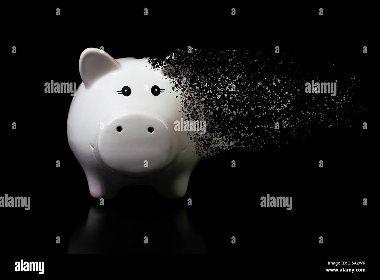White piggy bank dispersed on a very dark surface. Concept for economic crisis, inflation, devaluation, financial loss, devalued savings, market Stock Photo